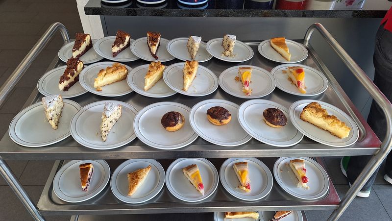 Servierwagen mit verschiedenen Kuchenschnitten für Frühlingsfeier
