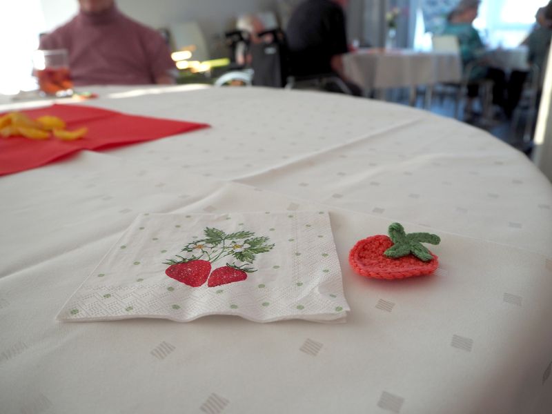 Tisch mit Serviette im Erdbeermotiv und gehäkeltem Dekostück beim Serenadenabend