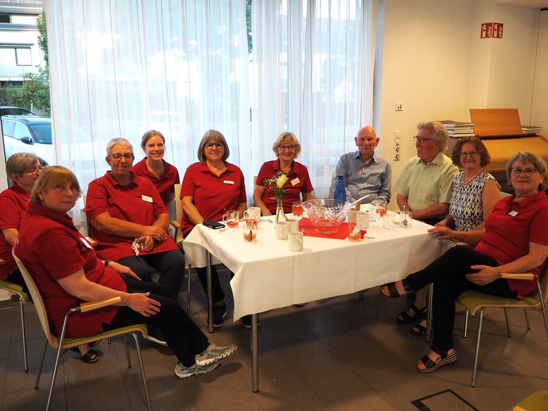 Personen in roten Poloshirts und Gäste an gedecktem Tisch beim Serenadenabend